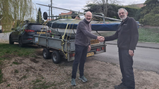 Two men shaking hands in front of a Wayfarer boat on a trailer. Credit: boat-disposal.co.uk
