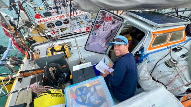 A man sitting on a boat preparing for Mini Globe Race Leg 3