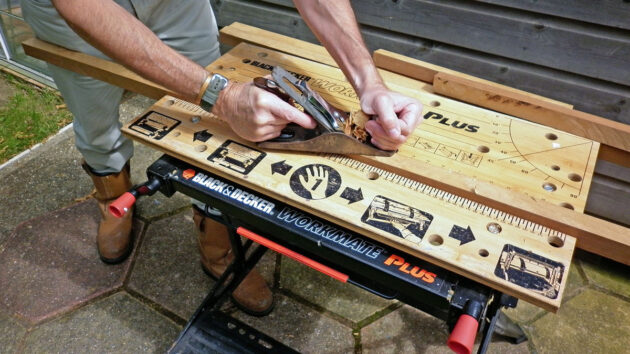 A man cutting wood on a workbench