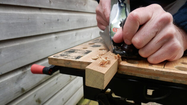 Wood being planed on a workbench