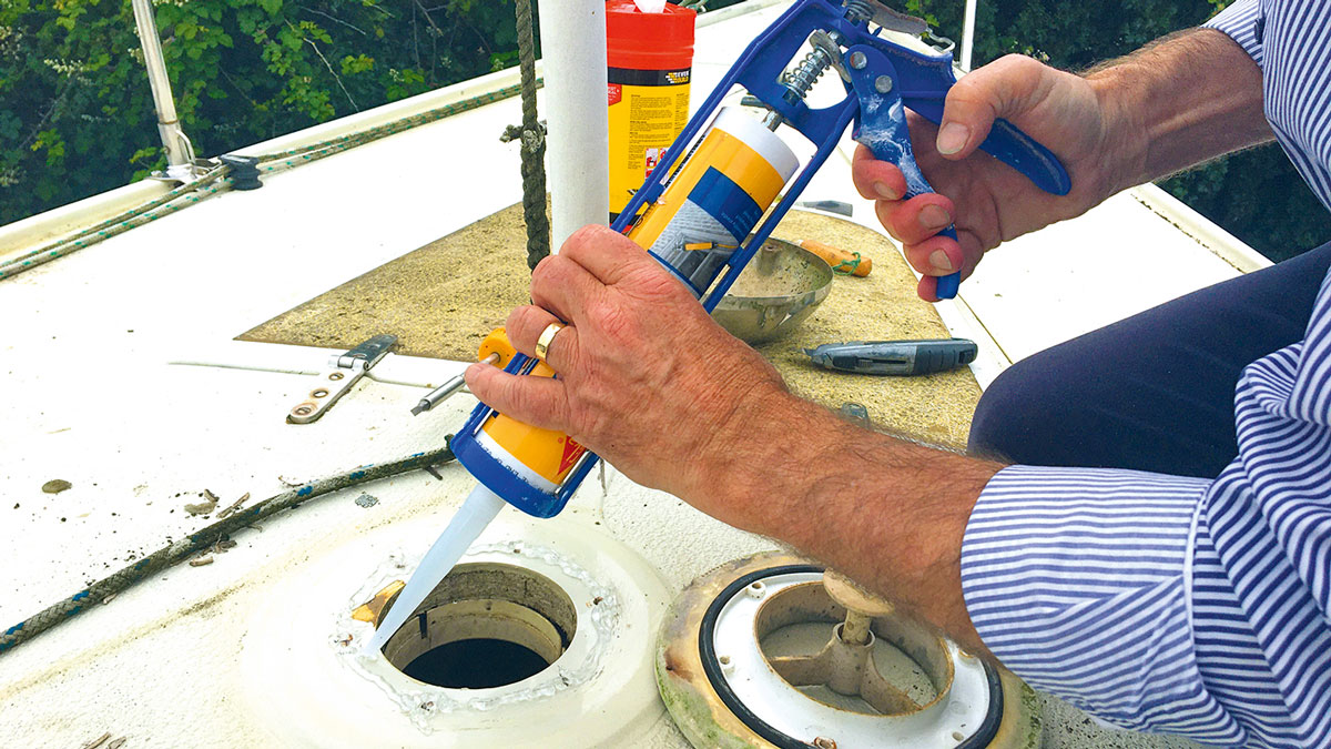 A man using marine sealants on a boat