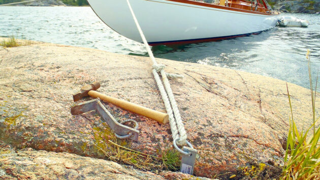 A boat moored using a shore line tied to a rock wedge