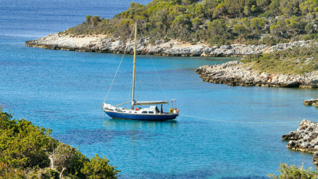 A boat anchored in a bay with a shore line