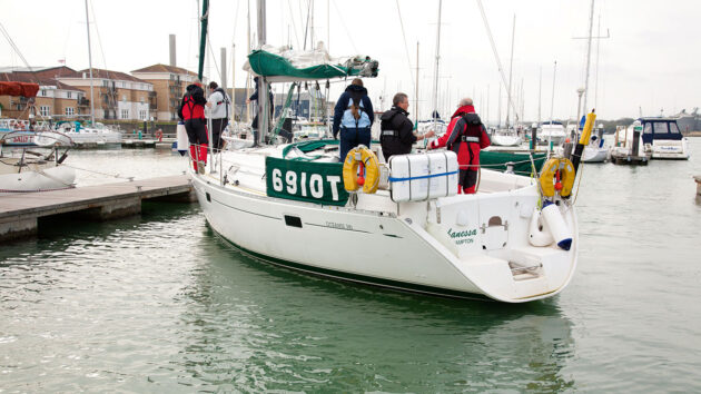 a yacht turning in a marina with crew on board
