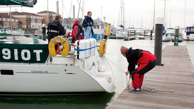 A person tying a line for a boat