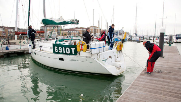 A yacht with crew carrying out marina berthing manoeuvres