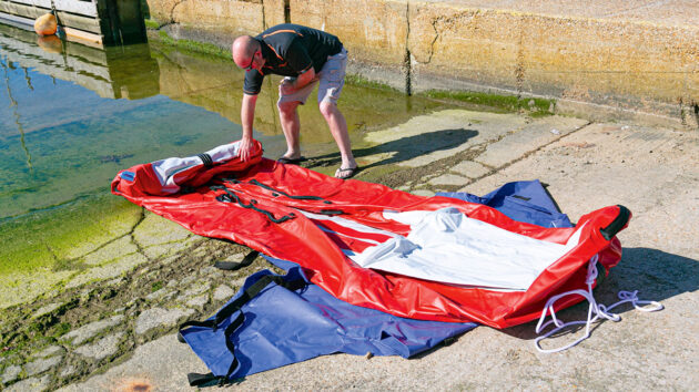 An inflatable boat being prepared for inflation on a slipway