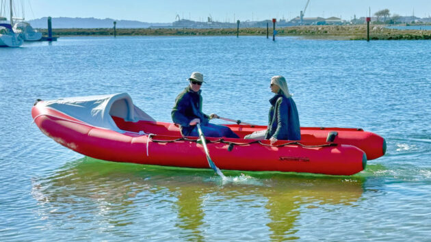Two people rowing a SpearFish 520 infatable boat in a harbour