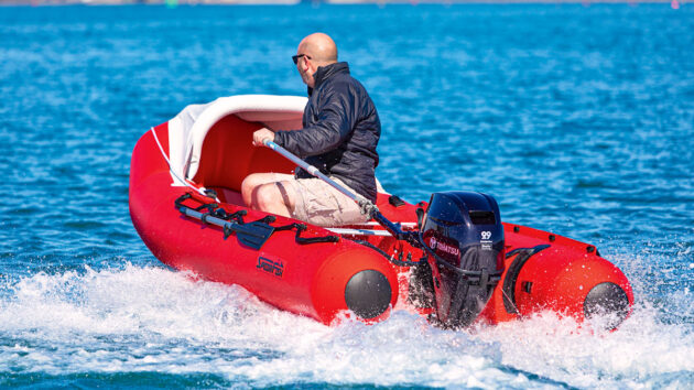A man using an outboard engine with a tiller on a SpearFish 520 inflatable boat