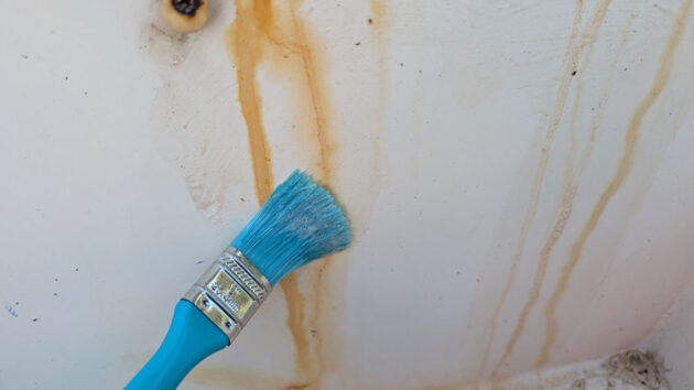 A person applying GRUNT! boat cleaner to a bulkhead