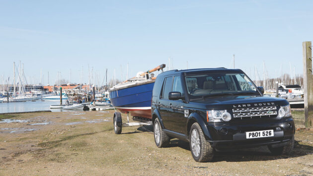 A boat trailer hooked up to a Land Rover