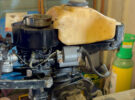 A person servicing a two-stroke outboard engine