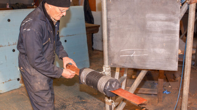 A man steaming a piece of wood for cold moulding