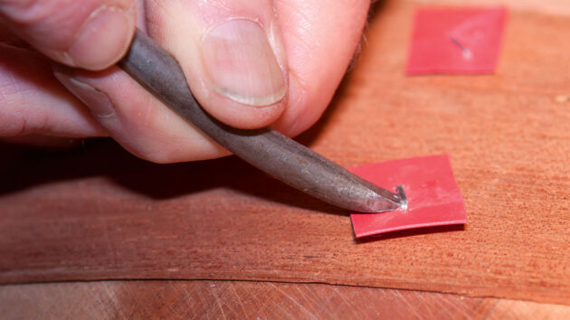 Staples being removed from the hull of a canoe during the cold moulding process