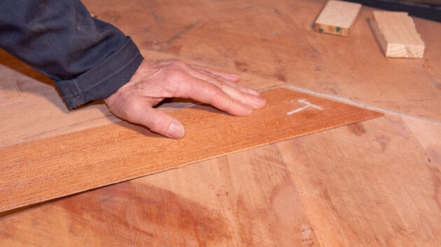 Veneers being laid on a hull of a canoe