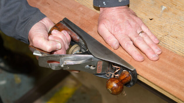 A man planing wood for cold moulding