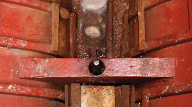 A sledgehammer being used to drive a keel bolt