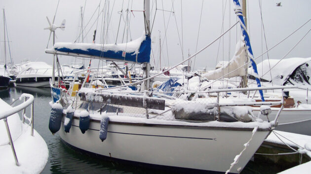 A boat moored in a marina covered in snow