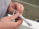 A man preparing rope for running rigging replacement on a boat