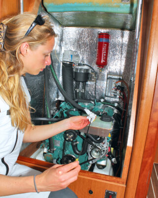 A woman checking a boat engine during an ocean crossing