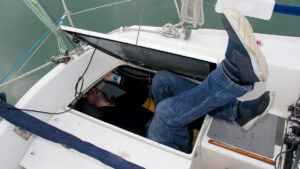 A person using tools for tight spaces on a boat