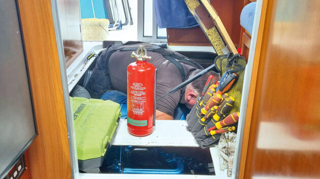 A man working in the engine bay of a Beneteau 760