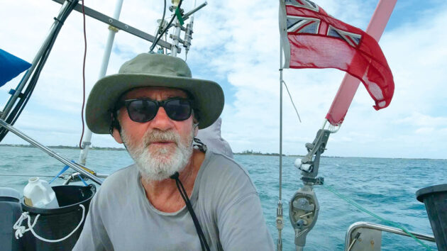 Sailor Barry Perrins wearing a hat and sunglasses on his boat