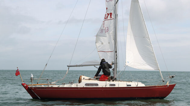 A man lowering a halyard on a slab reefing system