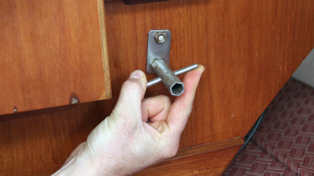 A person using a box spanner on a boat