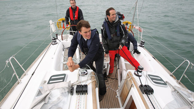 Men in a cockpit of a yacht sailing