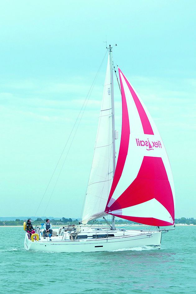 A yacht with a red and white sail