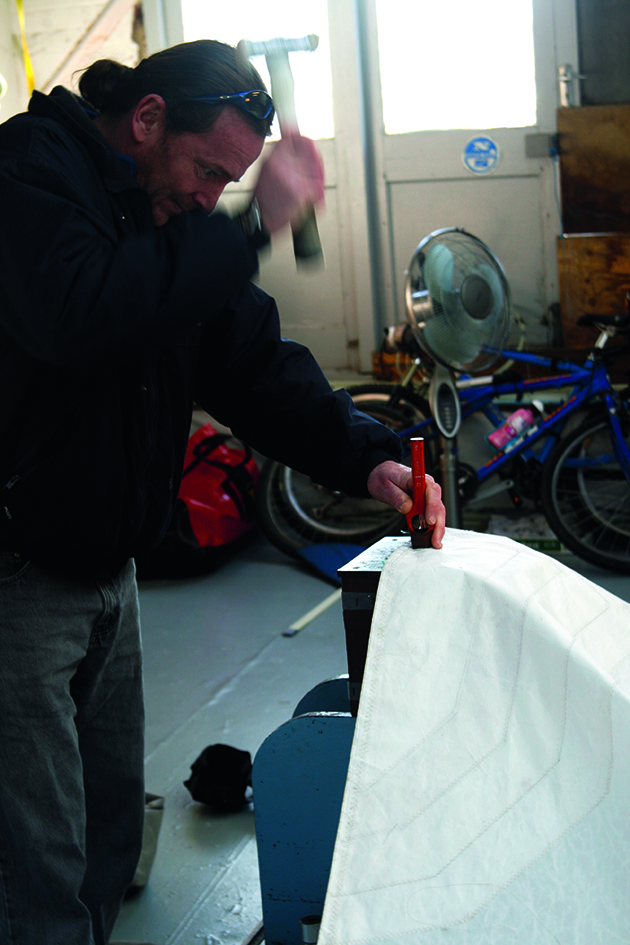 A man fitted spiked cringles to a sail