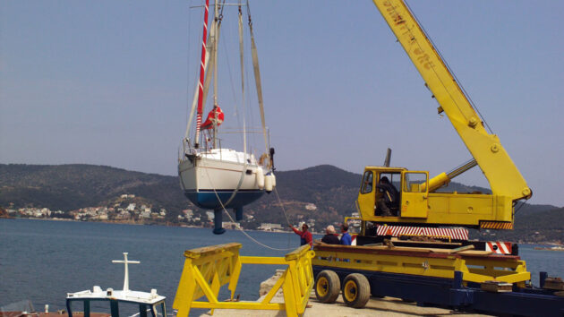 A yacht being launched via a crane