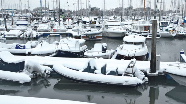 Boats moored in a snowy marina