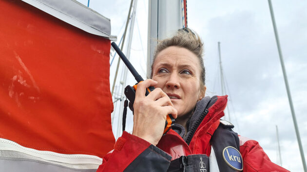 A woman using a VHF radio on a boat