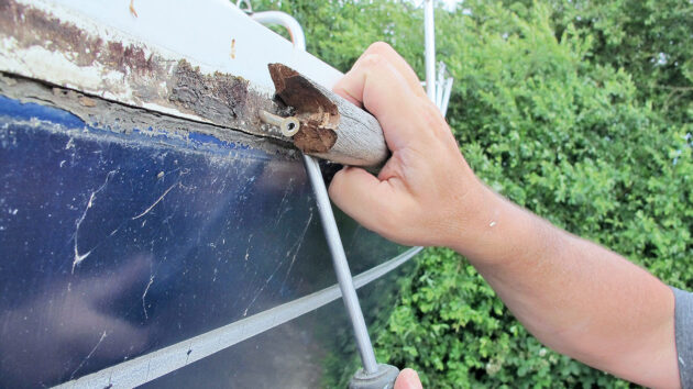Old teak gunwale being removed from a boat to be replaced with PVC gunwale