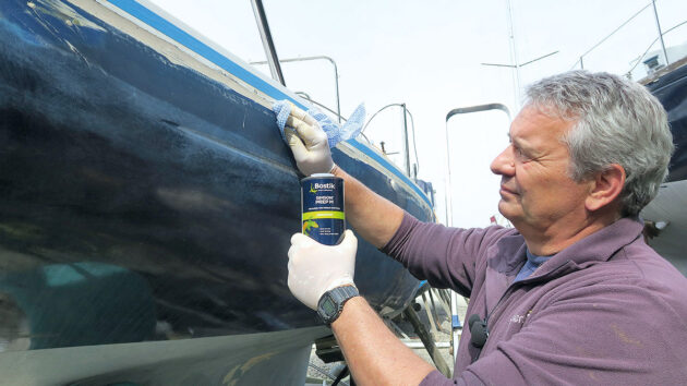 A man cleaning the topsides of a boat ahead of fitting PVC gunwale