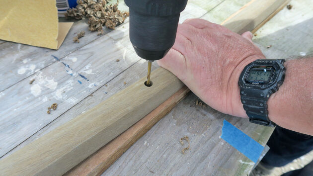 a man drilling holes in PVC gunwale