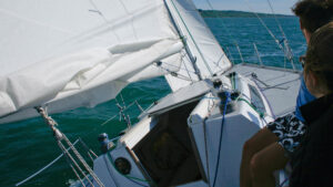 A yacht sailing along having had extra reefing points and luff slides added to the sails