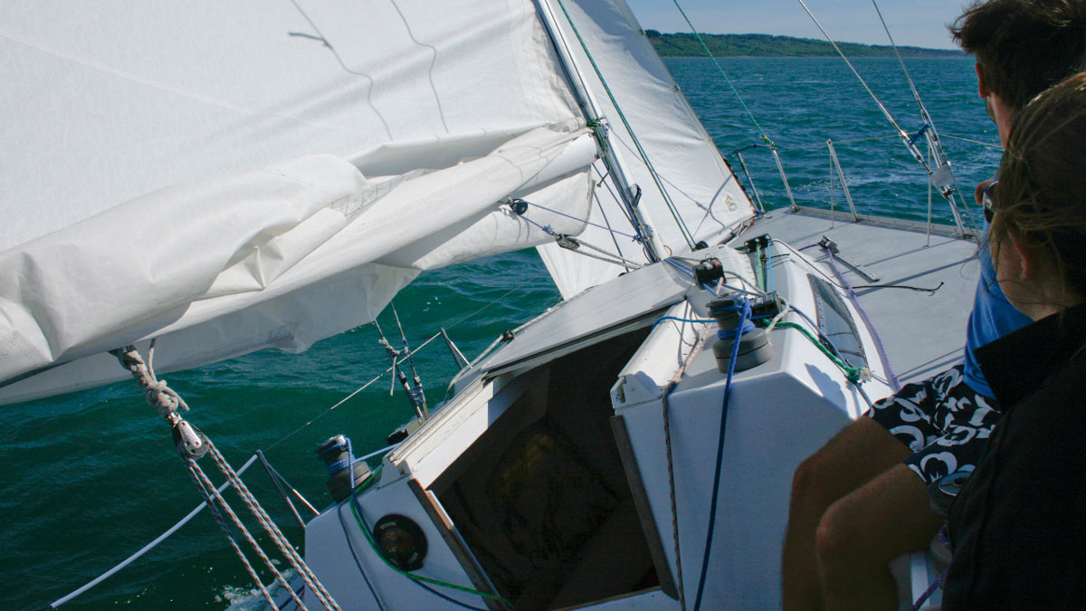 A yacht sailing along having had extra reefing points and luff slides added to the sails