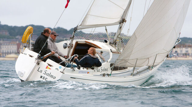 A Hustler 25.5 boat being sailed by three men