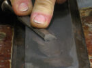 A man who is demonstrating how to sharpen a chisel