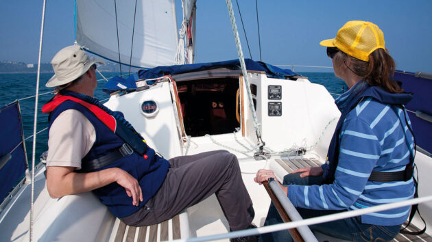 A man and a woman sailing a Jeanneau Sun Dream 28