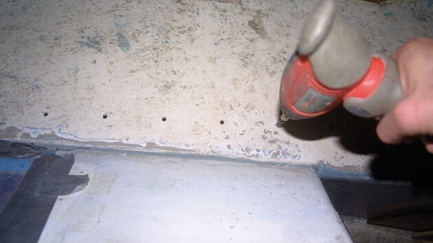 Bolt holes being filled on plywood decks on a boat