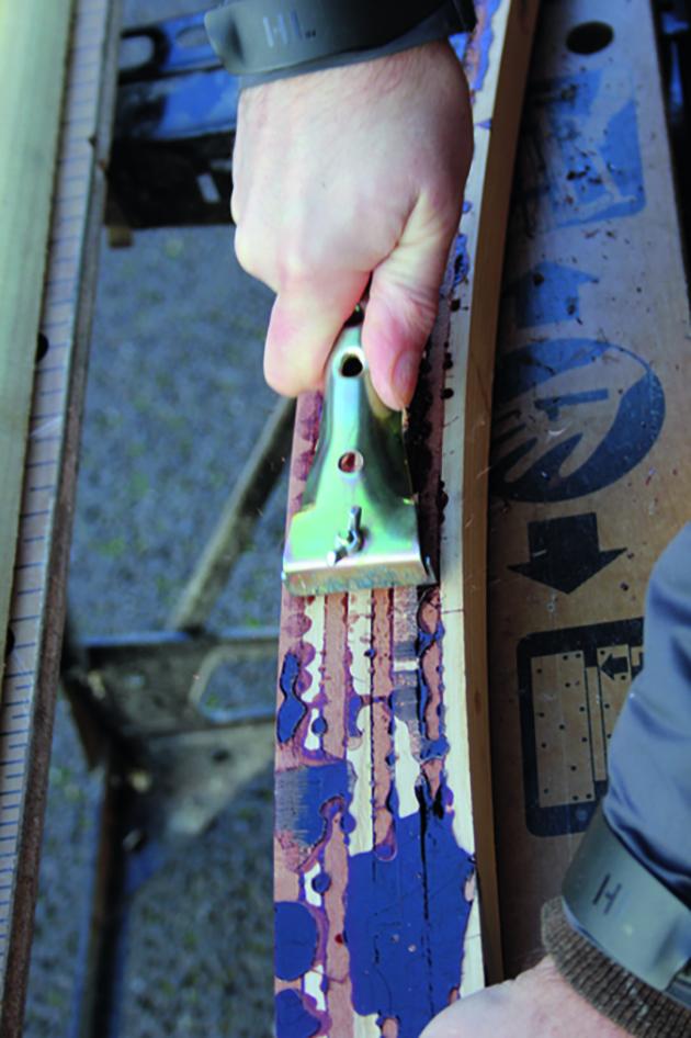 A man planing wood to make a tiller for a boat