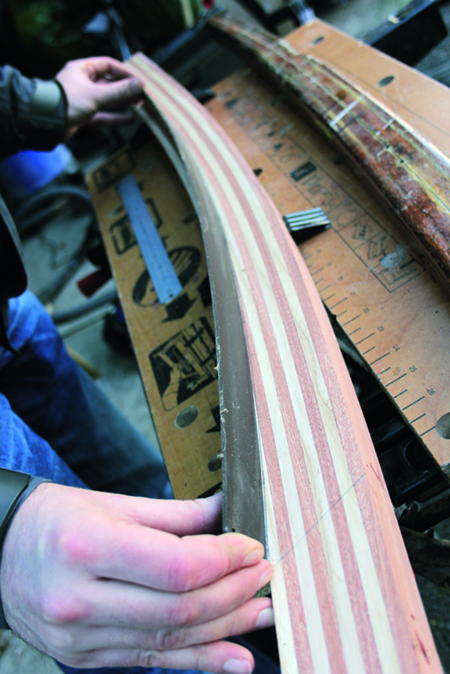 A man shaping wood to make a tiller for a boat