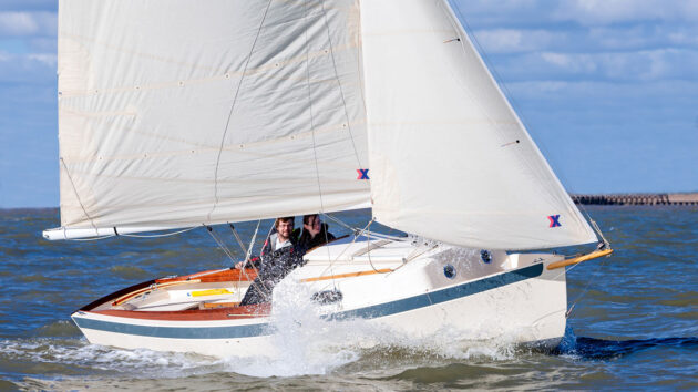 A boat with a white hull and white sails