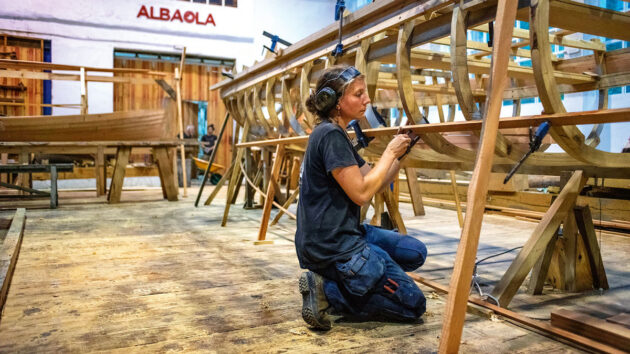 A woman wearing ear defenders boatbulding