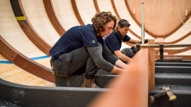 Women in a boatyard working on boatbuilding