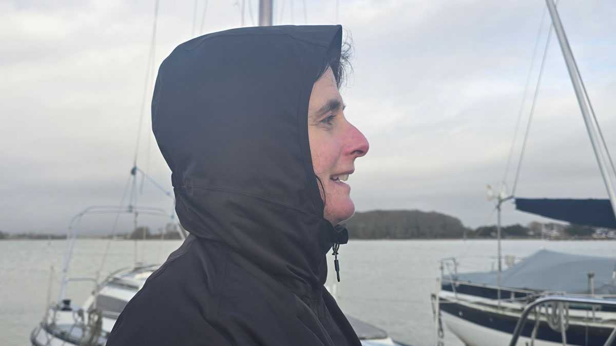 A woman wearing a blue jacket with the hood up